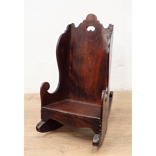 466 - An antique child's Rocking Chair in fruitwood having shaped surmount and sides, solid seat and pierc... 