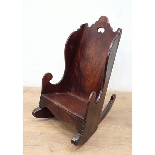 466 - An antique child's Rocking Chair in fruitwood having shaped surmount and sides, solid seat and pierc... 