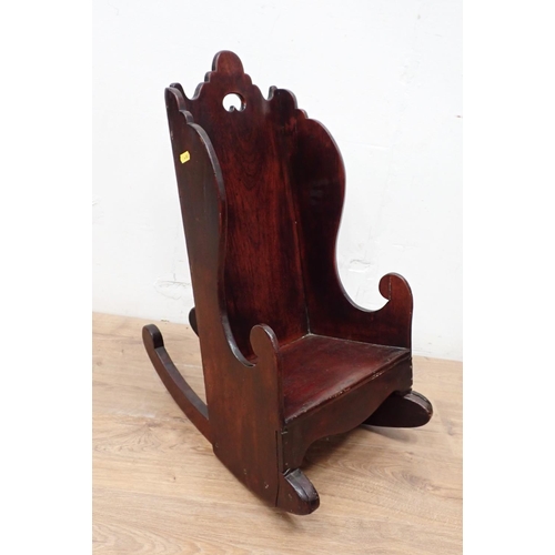 466 - An antique child's Rocking Chair in fruitwood having shaped surmount and sides, solid seat and pierc... 