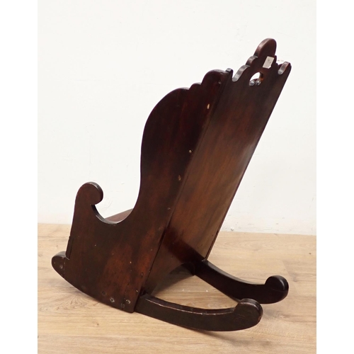 466 - An antique child's Rocking Chair in fruitwood having shaped surmount and sides, solid seat and pierc... 