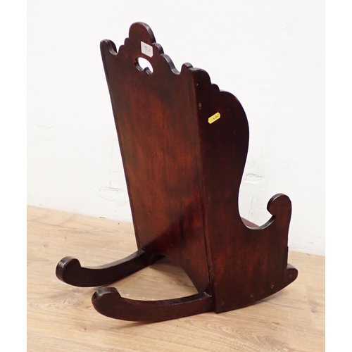 466 - An antique child's Rocking Chair in fruitwood having shaped surmount and sides, solid seat and pierc... 