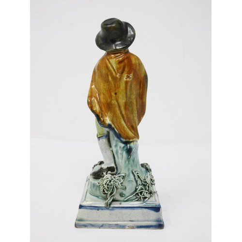 278 - An early 19th Century Prattware figure of 'Winter', wearing hat and cloak, on encrusted square stepp... 