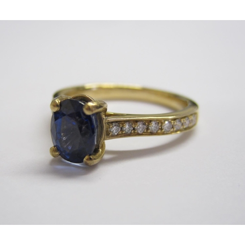 158 - A Sapphire and Diamond Ring claw-set oval-cut sapphire, 1ct, between rows of pavé-set brilliant-cut ... 