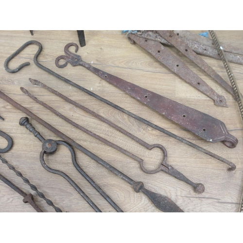 384 - A box of antique metal ware including Fire Irons, Hinges, Fire Crane, etc