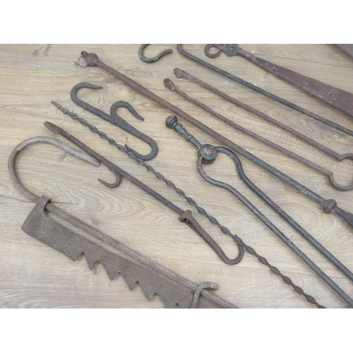 384 - A box of antique metal ware including Fire Irons, Hinges, Fire Crane, etc