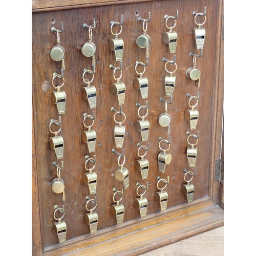 107 - An oak and glazed Display Cabinet containing thirty six Halex Whistles 2ft 1in H x 1ft 6in W