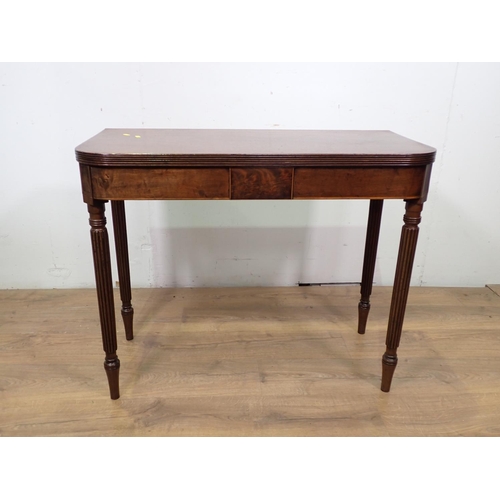 40 - A 19th Century mahogany and boxwood strung fold over Tea Table mounted upon fluted tapering supports... 