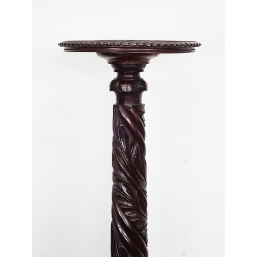 88 - A carved mahogany Torchere on claw and ball feet 4ft 5in H