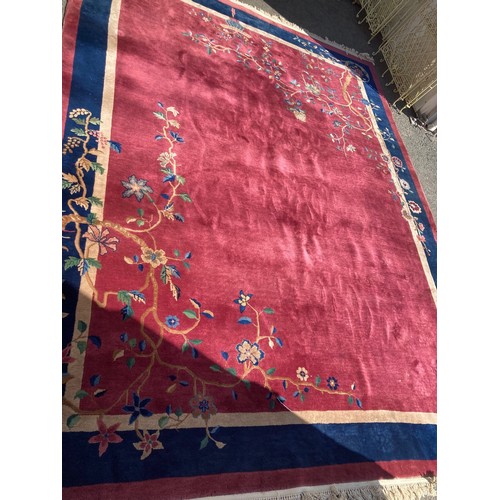 817 - A Chinese raspberry Carpet with tree design and blue border 12ft 2in L x 8ft 10in W