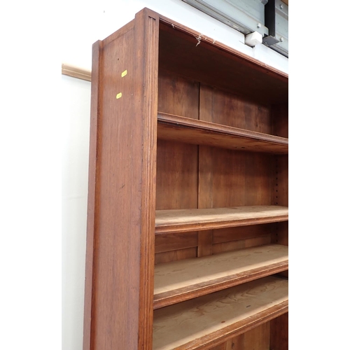 12 - An Edwardian oak open Bookcase with adjustable shelves above base fitted pair of cupboard doors 7ft ... 