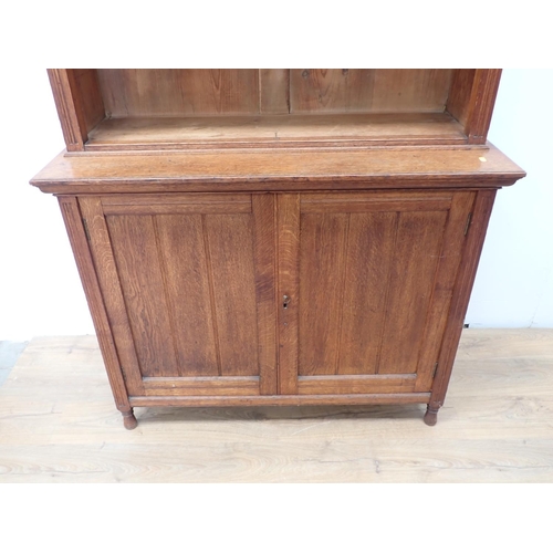 12 - An Edwardian oak open Bookcase with adjustable shelves above base fitted pair of cupboard doors 7ft ... 