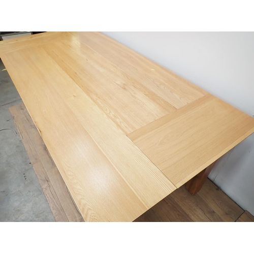 486 - A modern oak Dining Table on square cut tapering supports 7ft L x 2ft 5in H