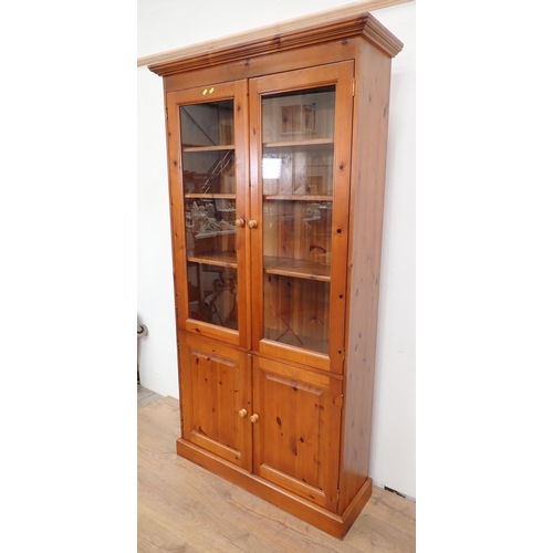 498 - A modern pine and glazed Bookcase fitted two cupboard doors below 6ft 5in H x 3ft 5in W