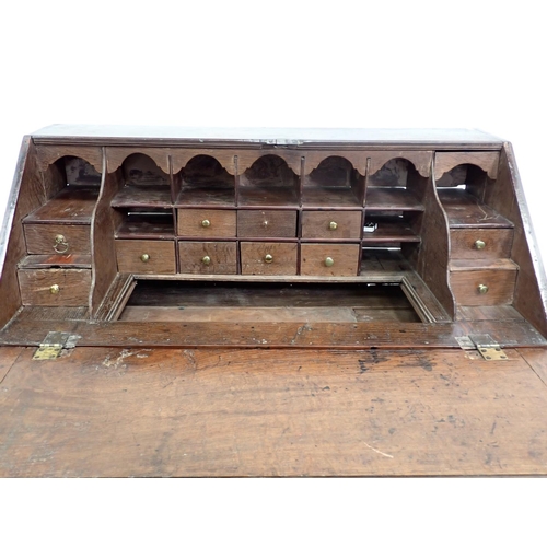 503 - An 18th Century oak Bureau, the interior fitted drawers, pigeon holes and well above three long draw... 