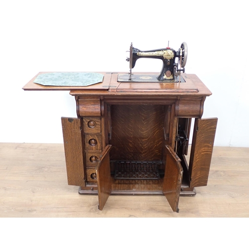 543 - A Singer Sewing Machine in oak Cabinet fitted hidden drawers 2ft 8in W x 2ft 8in H