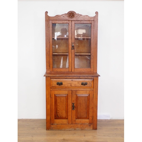 15 - An Art Noveau oak and glazed Bookcase above base fitted single frieze drawer and pair of cupboard do... 