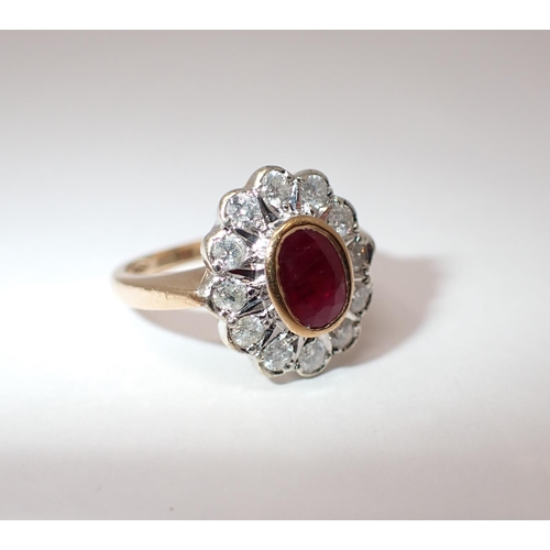 154 - A Ruby and Diamond Cluster Ring rubover-set oval-cut ruby within a frame of brilliant-cut diamonds i... 