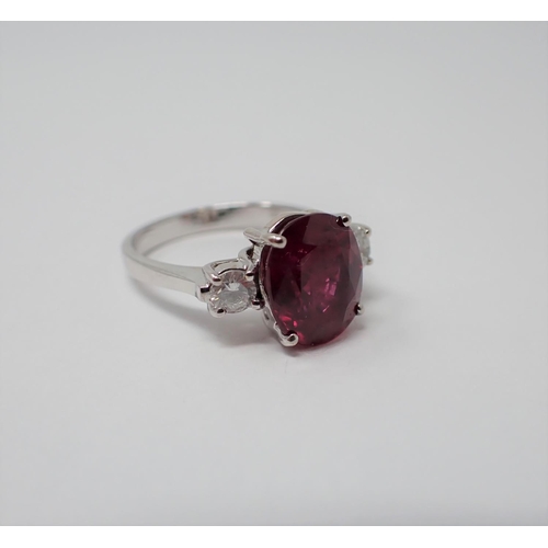 167 - A Ruby and Diamond three stone Ring claw-set oval-cut ruby, 3.34cts, between two brilliant-cut diamo... 