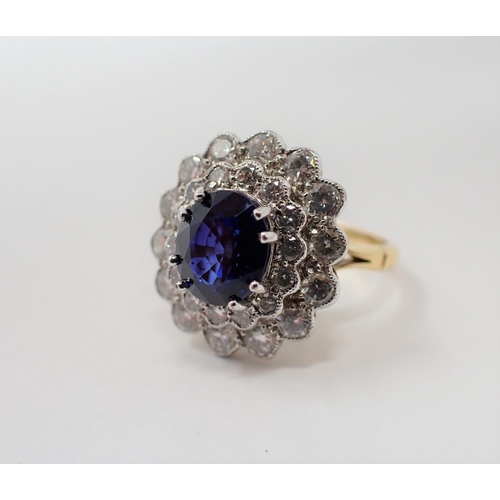 170 - A Sapphire and Diamond Cluster Ring claw-set oval-cut sapphire, 2.53cts, within double frame of mill... 