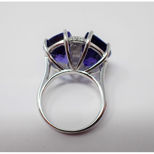 179 - A Tanzanite and Diamond Ring claw-set a pair of lunette-cut tanzanite, total weight 16.63cts, divide... 