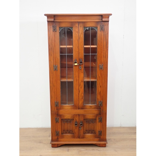 26 - An oak and lead glazed Bookcase fitted two linenfold cupboard doors to base 5ft 3in H x 2ft 5in W