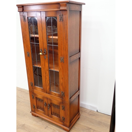 26 - An oak and lead glazed Bookcase fitted two linenfold cupboard doors to base 5ft 3in H x 2ft 5in W