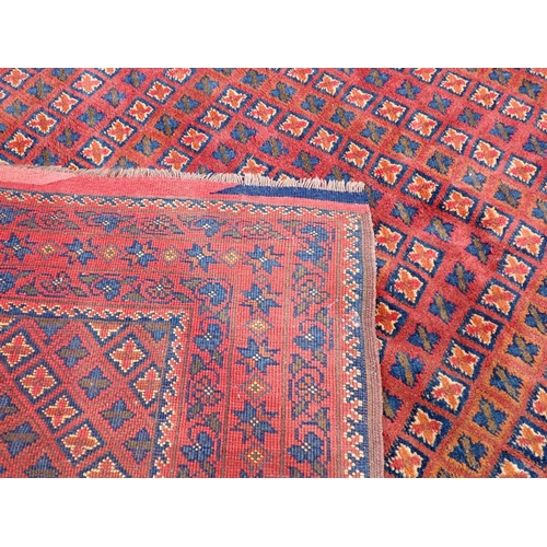 300 - An antique Turkoman Rug with multiple borders with floral designs, and rows of  motifs on a red grou... 