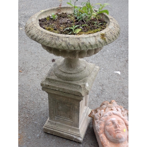 479 - A composite stone Urn on pedestal 2ft 8in H x 1ft 8in D and a terracotta Wall Pocket in the form of ... 