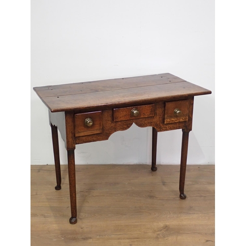 54 - An 18th Century oak Lowboy fitted three drawers above cupid's bow apron mounted upon turned supports... 