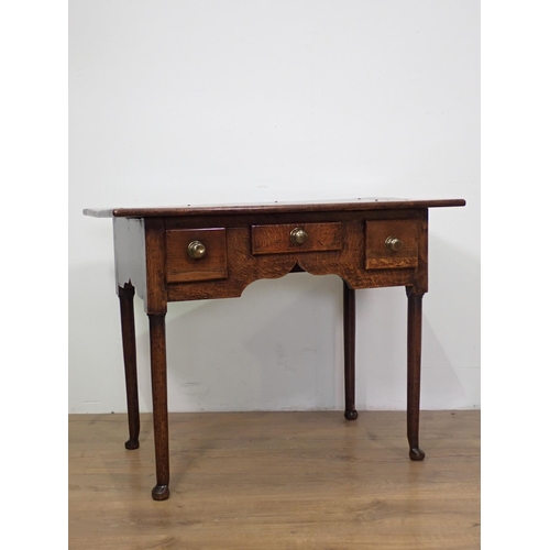 54 - An 18th Century oak Lowboy fitted three drawers above cupid's bow apron mounted upon turned supports... 