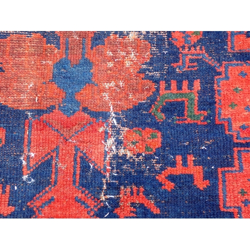 552 - A Persian Runner with red stylised motifs on a blue ground, 17ft x 4ft