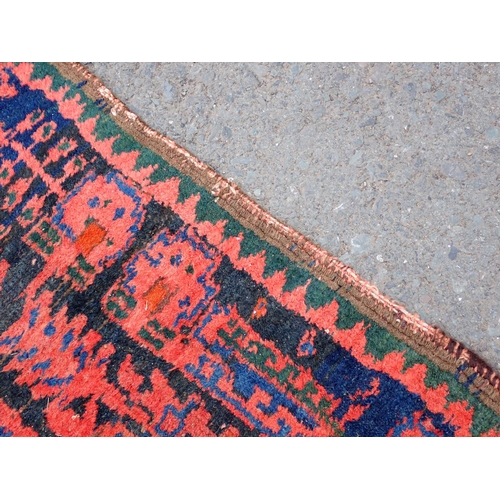 552 - A Persian Runner with red stylised motifs on a blue ground, 17ft x 4ft