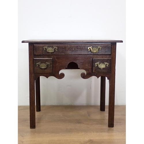 560 - An 18th Century oak Lowboy fitted three drawers above shaped apron mounted upon square cut supports ... 