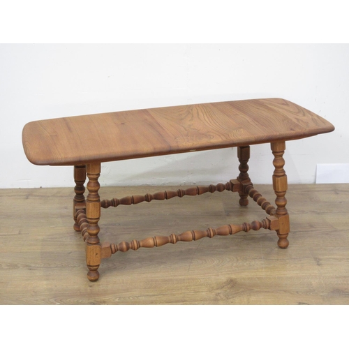 562 - An Ercol style elm Coffee Table on turned and square cut supports 3ft 4in W x 1ft 6in H