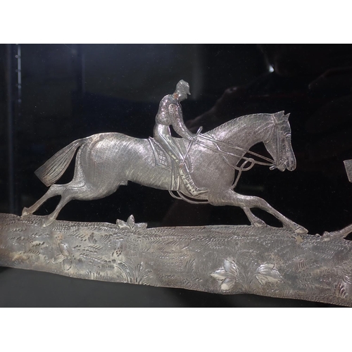 954 - A white metal Panel of three horses racing approaching a fence, 11 x 23in, framed and glazed