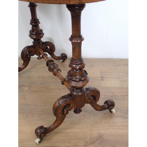 1029 - A Victorian walnut oval Centre Table on cheval frame with turned supports and stretchers, scroll fee... 