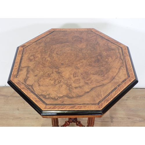 1030 - A Victorian walnut octagonal Table on turned and fluted supports and casters