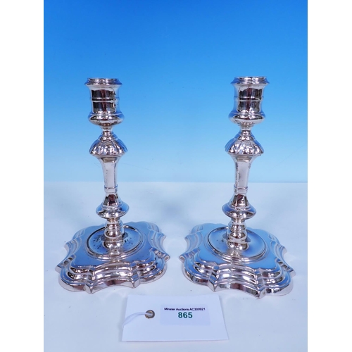 865 - A pair of George II silver cast Candlesticks with reel shaped sconces, knopped stems on shaped squar... 