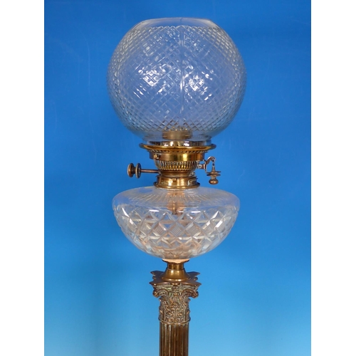 945 - A brass Oil Lamp having brass base with Corinthian capital, cut glass reservoir and shade, 2ft 6in