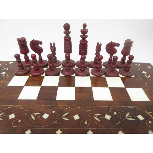 962 - A red and white carved bone Chess Set in an inlaid Indian folding case with chessboard, 12 x 6in