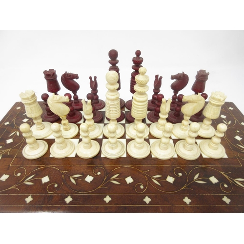 962 - A red and white carved bone Chess Set in an inlaid Indian folding case with chessboard, 12 x 6in