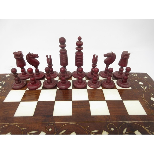 962 - A red and white carved bone Chess Set in an inlaid Indian folding case with chessboard, 12 x 6in