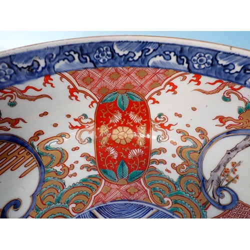 984 - A large Imari Bowl painted central fish surrounded by reserves of flowering shrubs in iron red, blue... 