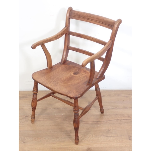 118 - An antique elm seated Elbow Chair with baluster turned supports and stretchers