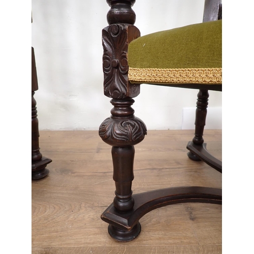 127 - A pair of elaborately carved Elbow Chairs with arched backs, stuff over seats on carved and turned s... 