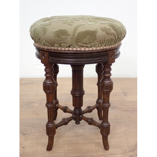 130 - A Victorian circular Piano Stool with rise and fall on turned supports and stretchers