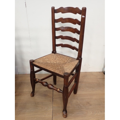 141 - A set of seven antique oak ladder back Chairs with rush seats, with turned supports and stretchers