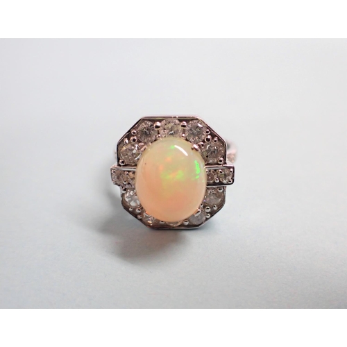 185 - An Art Deco style Opal and Diamond Ring claw-set oval opal cabochon within a frame of brilliant and ... 