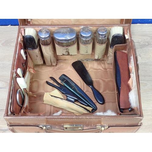 234 - A gentleman's leather Dressing Case with fitted interior and silver topped bottles in canvas outer c... 