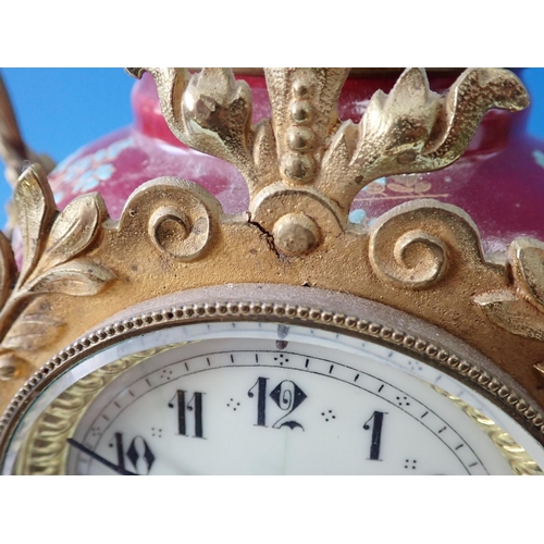 503 - A gilded metal Mantel Clock with porcelain panels of reclining cherub and floral wreath, chiming on ... 